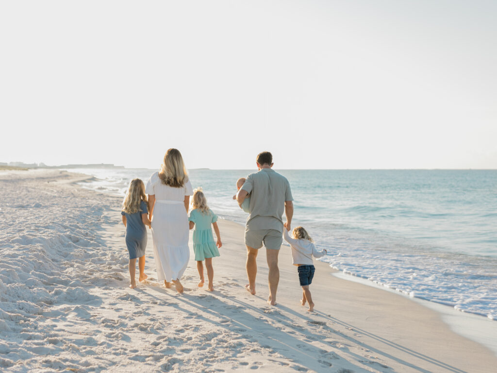 Family of 6 walking along Princess Beach in Destin, Fl.