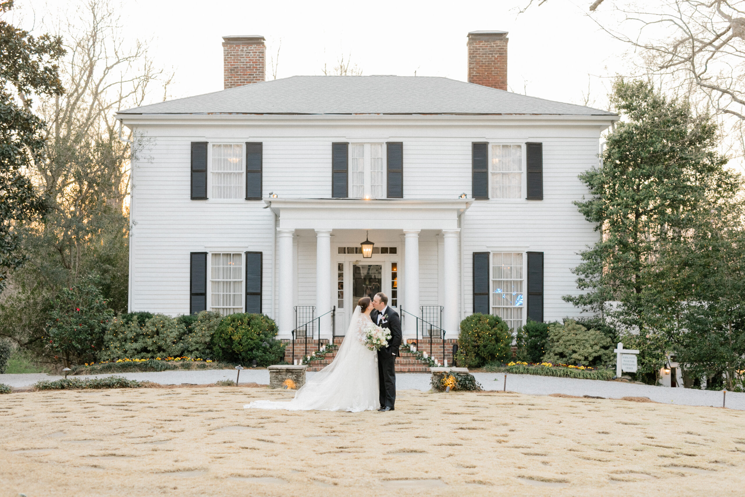 Bride and groom share a kiss in front of Primrose Cottage in Atlanta, GA